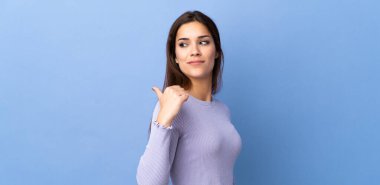 Tecrit edilmiş geçmişi olan beyaz bir kadın bir ürünü sunmak için kenarı işaret ediyor.