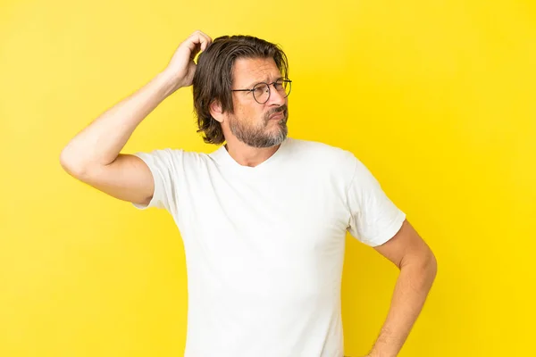 Senior Dutch Man Isolated Yellow Background Having Doubts While Scratching — Foto de Stock