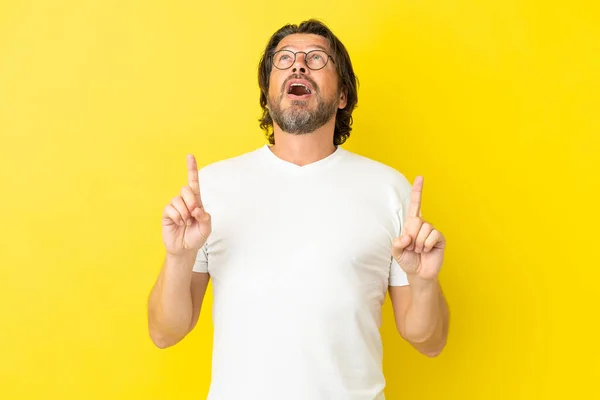 Senior Dutch Man Isolated Yellow Background Surprised Pointing —  Fotos de Stock