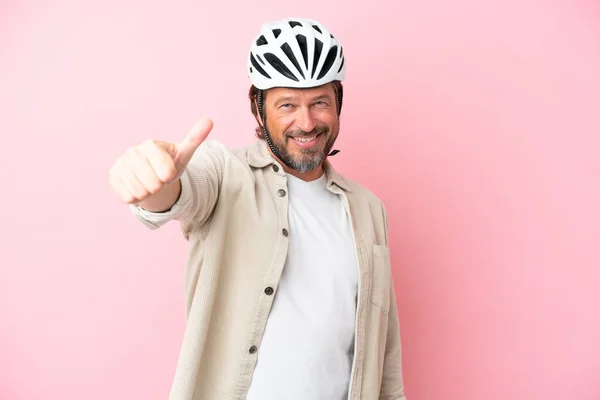 Senior Holland Férfi Kerékpáros Sisak Elszigetelt Rózsaszín Háttér Egy Hüvelykujj — Stock Fotó