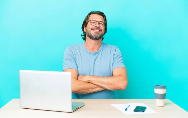 Senior Dutch Man Table Laptop Isolated Blue Background Keeping Arms — Stockfoto