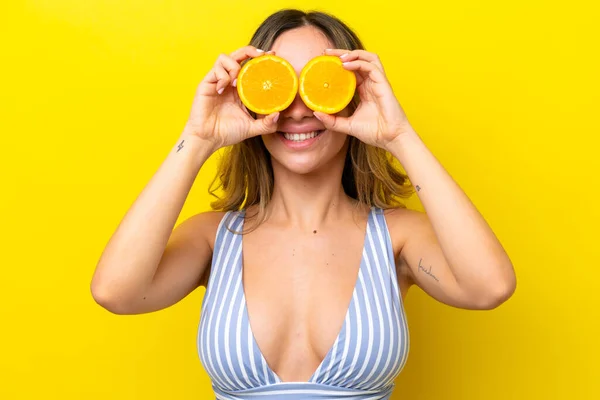 Young Caucasian Woman Isolated Yellow Background Swimsuit Holding Orange — Stok fotoğraf