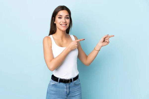 Jonge Kaukasische Vrouw Geïsoleerd Blauwe Achtergrond Verrast Wijzen Kant — Stockfoto