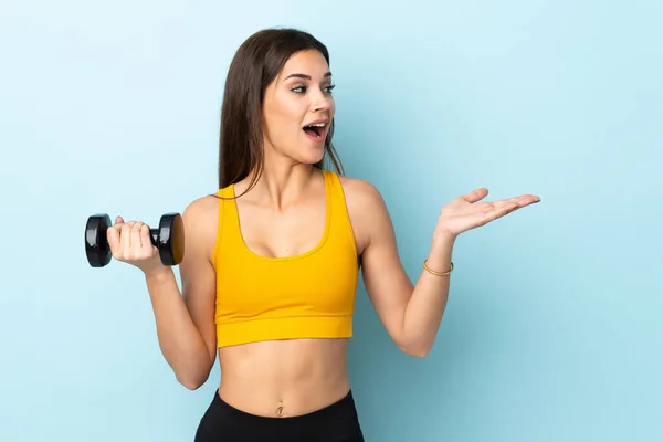 Young Caucasian Woman Making Weightlifting Isolated Blue Background Surprise Facial — Stock Fotó