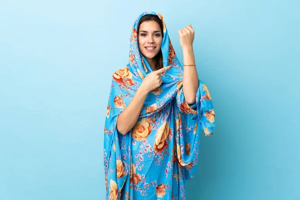 Young Moroccan woman with traditional costume isolated on blue background making the gesture of being late