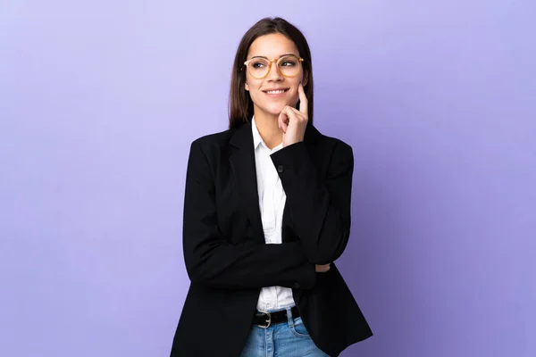 Business Woman Isolated Purple Background Thinking Idea While Looking — Zdjęcie stockowe