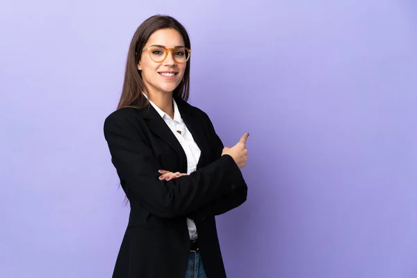 Business Woman Isolated Purple Background Pointing Back — Zdjęcie stockowe