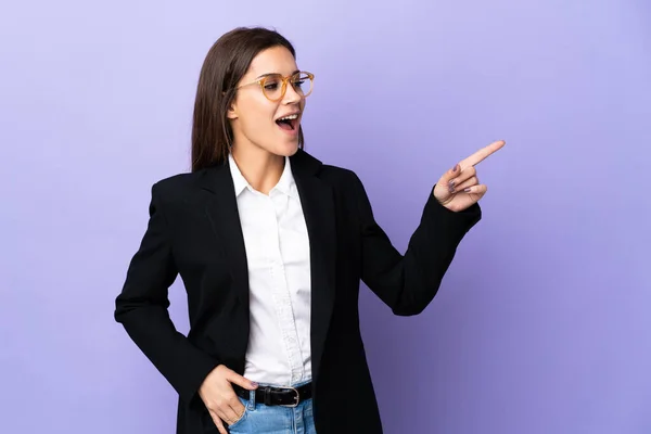 Business Woman Isolated Purple Background Pointing Finger Side Presenting Product — Zdjęcie stockowe