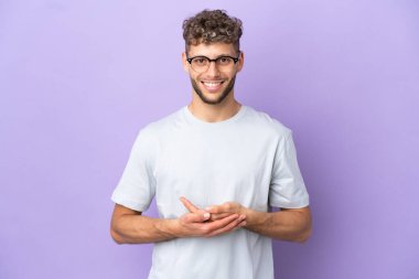 Mor arka planda izole edilmiş beyaz adam kahkahalar atıyor.