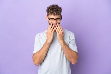 Delivery caucasian man isolated on purple background happy and smiling covering mouth with hands
