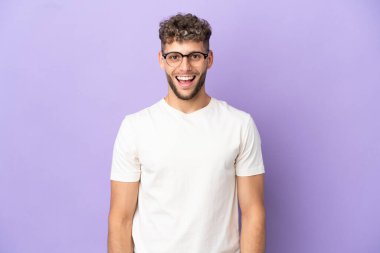 Teslimatçı beyaz adam mor arka planda izole edilmiş, şaşırmış yüz ifadesi var.