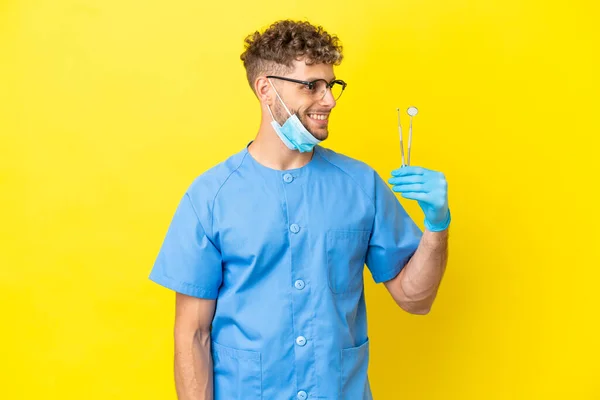 Dentist Blonde Man Holding Tools Isolated Background Looking Side — Fotografia de Stock