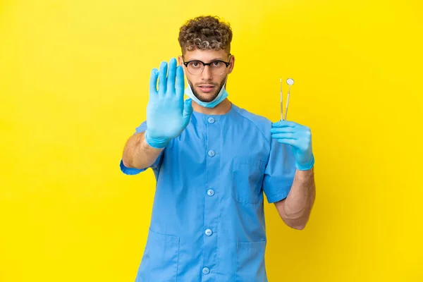 Dentist Blonde Man Holding Tools Isolated Background Making Stop Gesture — Fotografia de Stock
