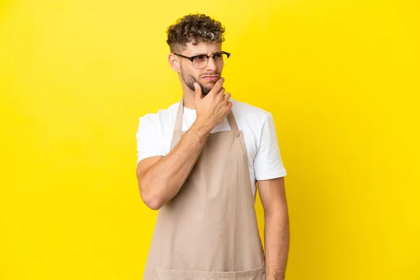 Restaurant Waiter Blonde Man Isolated Yellow Background Having Doubts Confuse — Stok fotoğraf