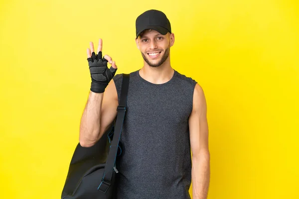 Young Sport Blonde Man Sport Bag Isolated Yellow Background Showing — Zdjęcie stockowe
