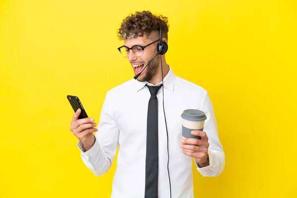 텔레마 금발의 남자가 배경에 분리되어 커피를 수있는 헤드폰을 일하고 — 스톡 사진