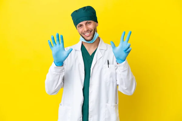 Χειρούργος Ξανθός Άνδρας Πράσινη Στολή Απομονώνεται Κίτρινο Φόντο Καταμέτρηση Οκτώ — Φωτογραφία Αρχείου