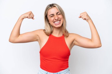 Beyaz arka planda izole genç beyaz kadın güçlü bir jest yapıyor.