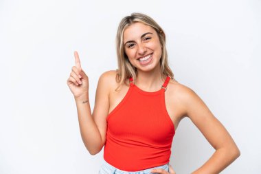 Beyaz arka planda izole edilmiş genç beyaz kadın en iyinin işareti olarak parmağını kaldırıyor ve gösteriyor.