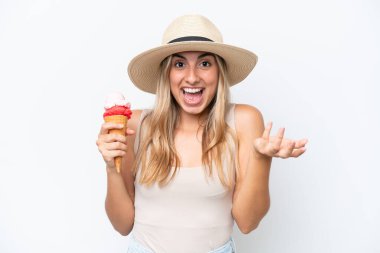 Young caucasian woman with a cornet ice cream isolated on white background with shocked facial expression
