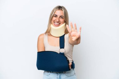 Woman with broken arm and wearing a sling isolated on white background happy and counting four with fingers