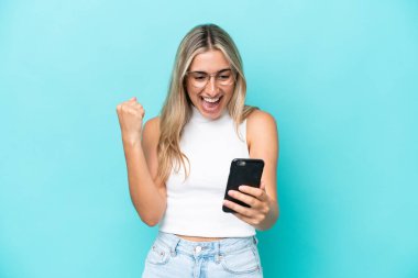 Mavi arka planda izole genç beyaz kadın şaşırdı ve bir mesaj gönderiyor.