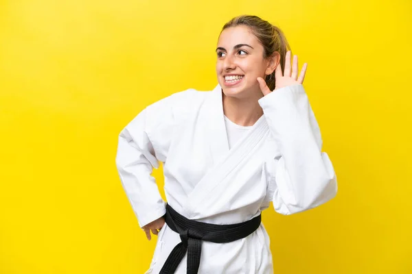 Young Caucasian Woman Doing Karate Isolated Yellow Background Listening Something — Foto de Stock