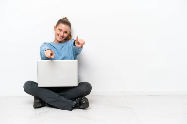 Junge Frau Mit Laptop Auf Dem Boden Zeigt Lächelnd Mit — Stockfoto