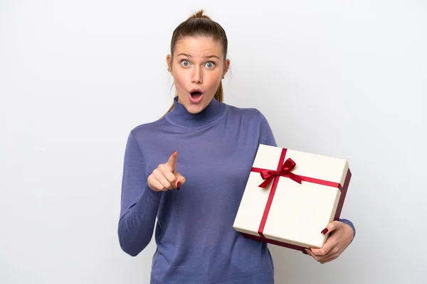 Young Caucasian Woman Holding Gift Isolated White Background Surprised Pointing — Stockfoto