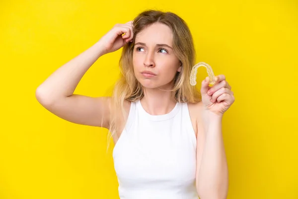 Blonde English Young Girl Holding Invisible Braces Isolated Yellow Background — Fotografia de Stock