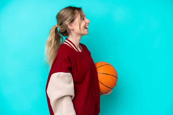 Young Basketball Player Caucasian Woman Isolated Blue Background Laughing Lateral — Stock Photo, Image