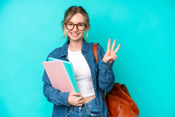 Young student woman isolated on blue background happy and counting three with fingers