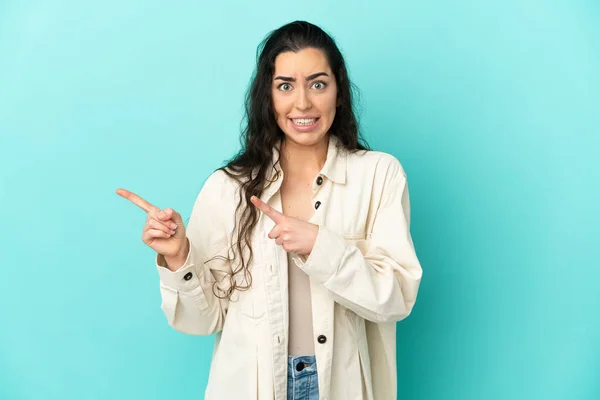 Giovane Donna Caucasica Isolato Sfondo Blu Spaventato Indicando Lato — Foto Stock