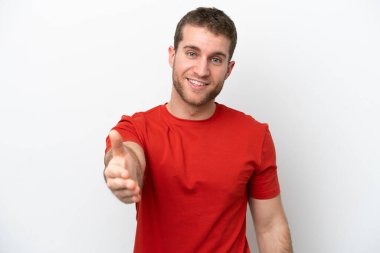 Beyaz arka planda izole edilmiş genç beyaz adam iyi bir anlaşma için el sıkışıyor.