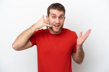 Beyaz arka planda izole edilmiş genç beyaz bir adam telefon jesti yapıyor ve şüpheli.