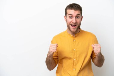 Beyaz arka plandaki beyaz tenli genç adam galibiyeti kutluyor.