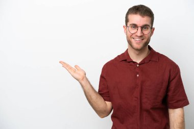 Beyaz arka planda izole edilmiş genç beyaz bir adam bir ilan vermek için avucunun içinde hayali bir fotokopi makinesi tutuyor.