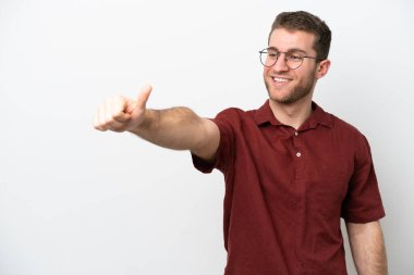 Beyaz arka planda izole edilmiş genç beyaz bir adam baş parmak hareketi yapıyor.