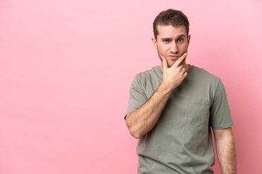 Pembe arka planda soyutlanmış beyaz bir adam.