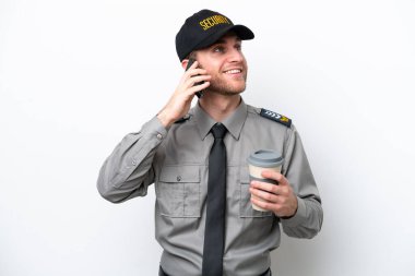 Beyaz arka planda izole edilmiş beyaz güvenlik görevlisi elinde kahve ve cep telefonu var.