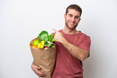 Beyaz arka planda izole edilmiş bir alışveriş çantası tutan beyaz bir adam.