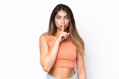 Beyaz arka planda izole edilmiş beyaz bir kadın sessiz bir jest işareti gösteriyor. Parmağını ağzına sokuyor.