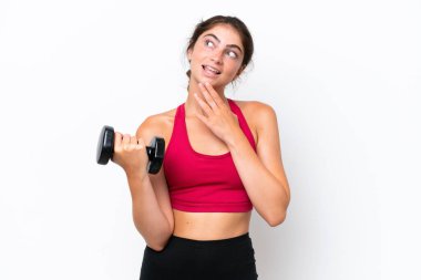 Young sport caucasian woman making weightlifting isolated on white background looking up while smiling