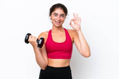 Young sport caucasian woman making weightlifting isolated on white background showing ok sign with fingers