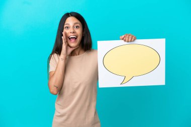 Young woman over isolated background holding a placard with speech bubble icon and shouting