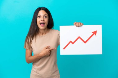 İzole edilmiş genç bir kadın elinde büyüyen bir istatistik ok sembolü ve şaşırmış ifadesiyle bir tabela tutuyor.