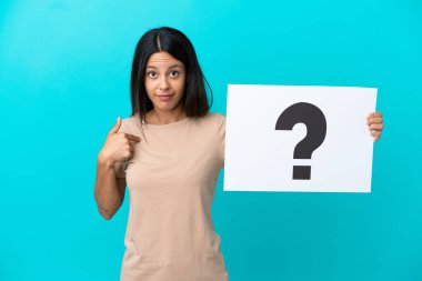 Arka planda izole edilmiş genç bir kadın elinde soru işareti ve şaşırmış ifade olan bir pankart tutuyor.