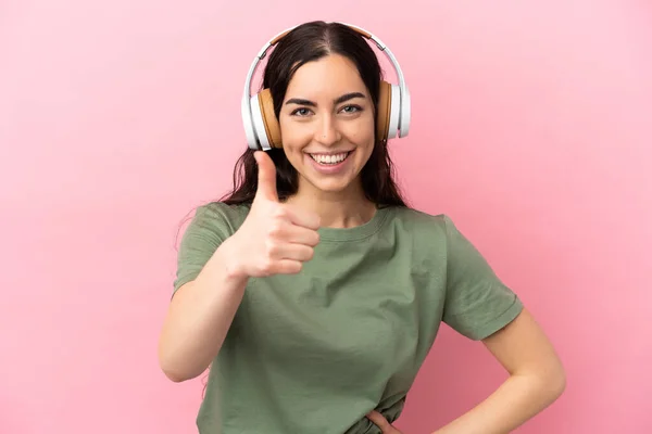 Jonge Kaukasische Vrouw Geïsoleerd Roze Achtergrond Luisteren Muziek Met Duim — Stockfoto