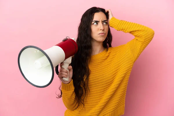 Young Caucasian Woman Isolated Pink Background Holding Megaphone Having Doubts — Stockfoto
