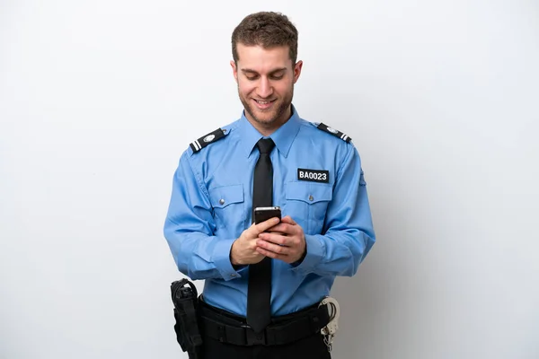 Молодой Кавказский Полицейский Изолированный Белом Фоне Отправляет Сообщение Мобильником — стоковое фото